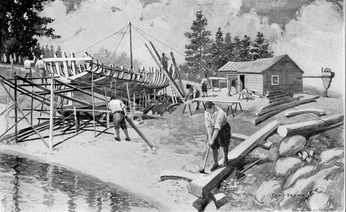A black and white drawing of several men building a ship in an outdoor field along a body of water. The curved skeleton of the ship is located on the left side of the drawing. The men in the drawing are all doing different jobs to help build the boat: one is splitting pieces of long wood with an axe, one is sawing pieces of thin wood, one is carrying a piece of wood to the ship, and several stand on top of the ship with hammers.