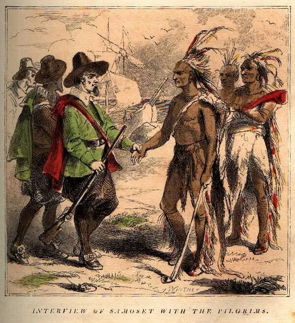 A drawing shows two groups of men in color, and, in the background, a two-masted ship in the water outlined in black and white. There are three men in the righthand ground, and they are dressed as traditional Native Americans. They have feather headdresses, clothing of animal skins covering parts of their bodies, and long horns. The three men on the left are dressed as traditional pilgrims. They have short, blousy pants, coats and cloaks, and black hats with wide brims all around. The man in front carries a rifle. The two men in front of each group are shaking hands. Under the picture, the words "Interview of Samoset with the pilgrims" appears. 
