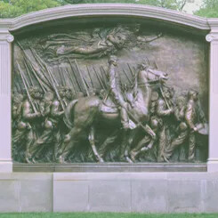 Bronze relief sculpture of the 54th Massachusetts Regiment, featuring soldiers marching with rifles and a mounted officer.
