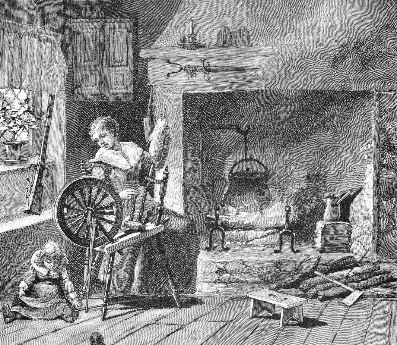 A black and white drawing of the interior of a house. On the left side of the drawing, a woman sits behind a tall table with a large wheel attached to it, looking at a small child playing on the floor. To the right of the woman is a large fireplace, with a large pot hung over a fire. On the ground in front of the fireplace is a pile of small pieces of wood and a small stool.