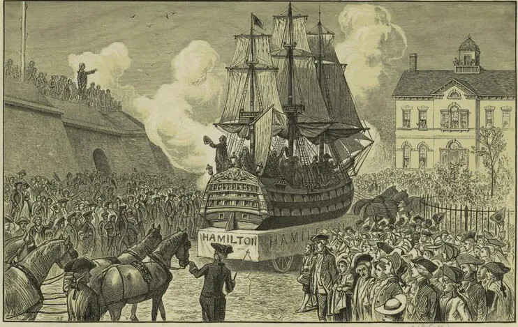 A black and white drawing of a large ship with three tall masts being carried through a crowd of people on a horse-drawn float. The float is labeled "HAMILTON." Another horse-drawn float, being led by a man in a long coat and a tri-corned hat, is seen emerging from the bottom left-hand corner.