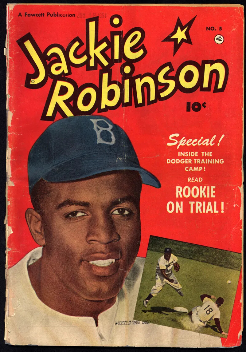 A red cover of a magazine is seen. A man's head and shoulders encompass most of the cover; he is wearing a blue cap with a "B" on it and a white shirt. A small drawing insert at the bottom shows a man catching a ball while another man slides into a base. In large yellow letters are the words "Jackie Robinson," then below it says "Special! Inside the Dodger Training Camp! Read Rookie on Trial!" 