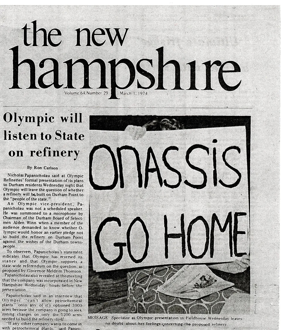 A vertical newspaper article from the publication called "the new hampshire." The title of the newspaper article, located on the left-hand side of the page, reads "Olympic will/listen to State/on refinery." A black and white photograph next to the article shows a woman in a polka-dot dress holding a sign that reads "ONASSIS/GO HOME."